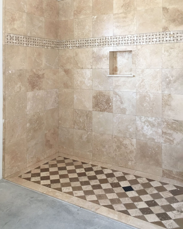 Travertine tile shower with diamond shaped tile floor