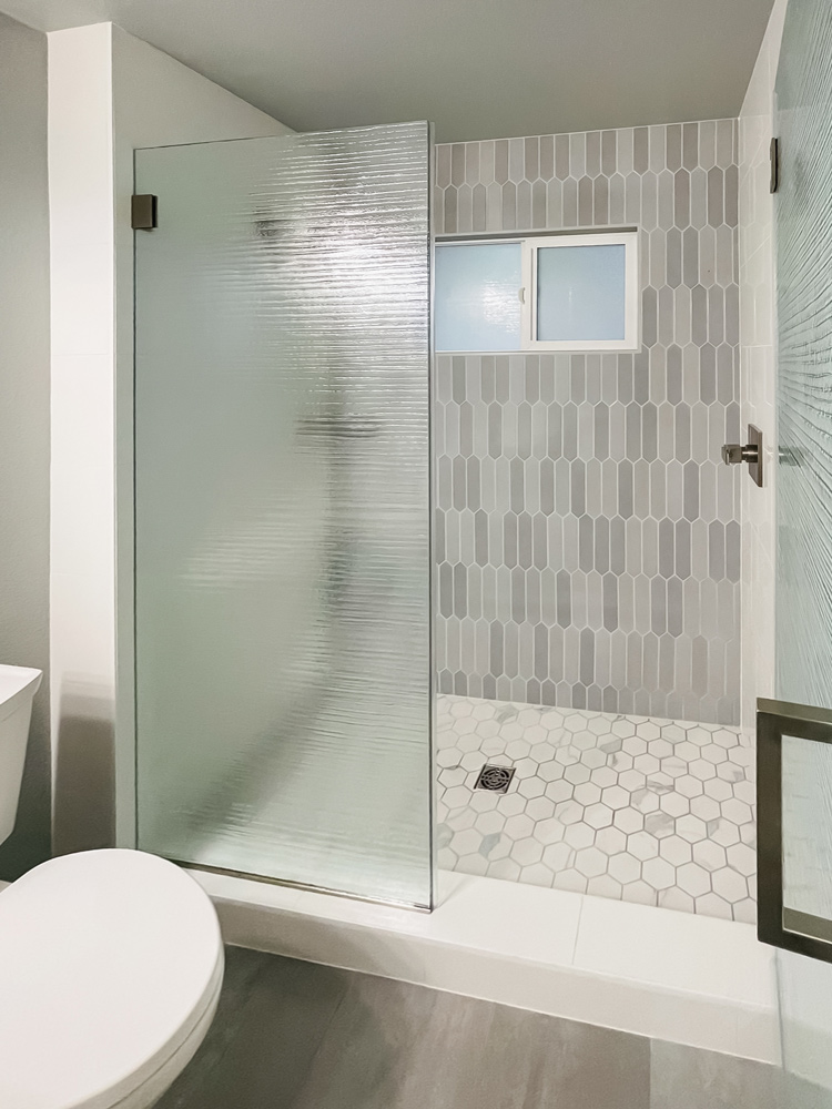 Custom shower with picket shaped multishade grey tiles