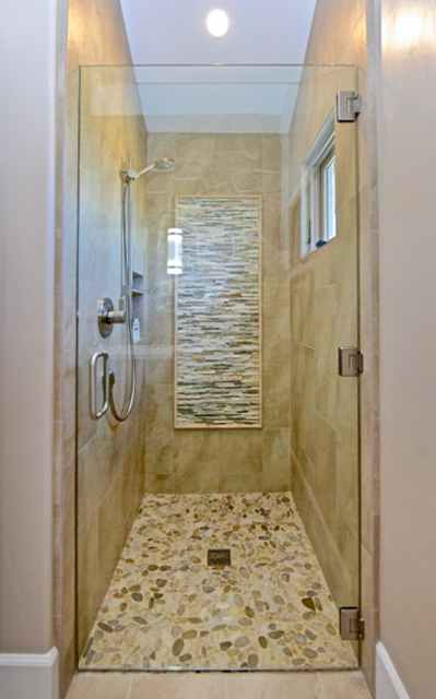 Stall shower with pebble floors and custom design wall feature