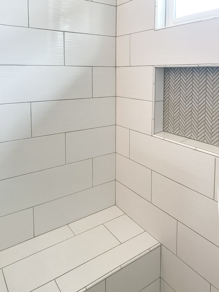 White rectangular tile in shower with bench