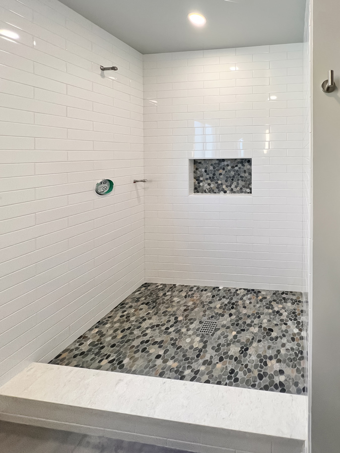 Rectangular Tile Shower with Pebble Floor and Niche