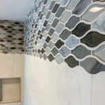 This image shows glass decorative tiles set in a wave pattern. The adjacent tiles are scribed to perfectly fit the curves of the accent tiles.