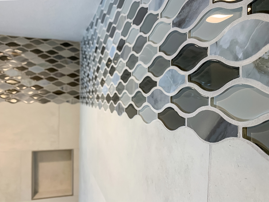 This image shows glass decorative tiles set in a wave pattern. The adjacent tiles are scribed to perfectly fit the curves of the accent tiles.