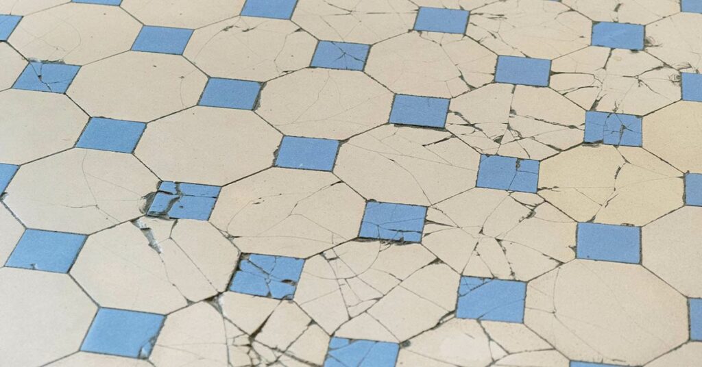 Tile floor with a lot of cracked and broken tiles.