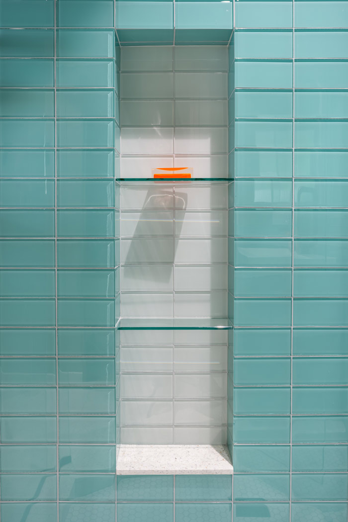 Aqua colored glass tile niche in shower