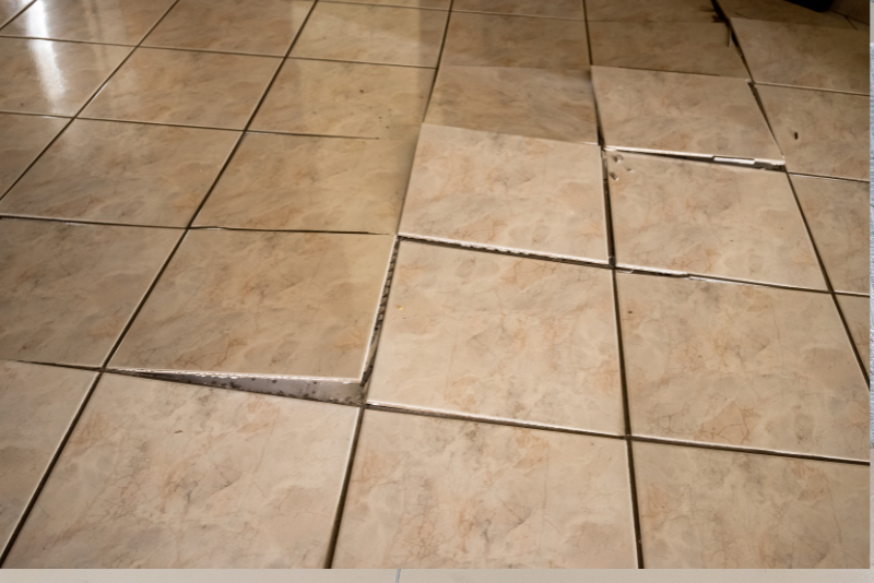 Loose or hollow floor tiles close up showing damage